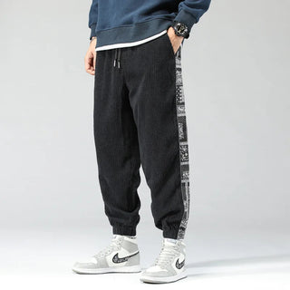 A pair of men's corduroy pants featuring a relaxed fit, stylish side print, and a modern versatile design, made from soft cotton material for comfort 0