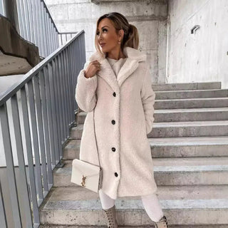 A long, elegant women's teddy coat designed for winter, made from soft, warm material featuring a classic silhouette that combines style and comfort, perfect for chilly 0