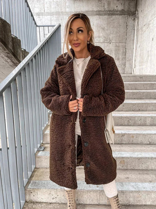 A women's long teddy coat, elegantly designed for winter, made from soft and warm material, featuring a cozy silhouette that combines style with comfort for cold weather 3