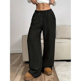 A pair of women's high-waisted trousers, featuring a relaxed fit and modern style, made from lightweight fabric. These versatile pants are suitable for both office 3