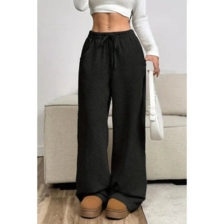 A pair of women's high-waisted, loose-fitting trousers in a modern style, crafted from soft, breathable fabric. These versatile pants are suitable for both 4