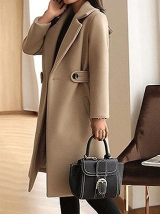 A long, elegant black women's coat made from high-quality fabric, featuring a timeless design ideal for winter wear. The sophisticated style is perfect for both casual 2